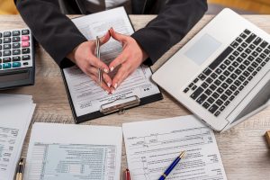 young woman work with tax form 2022. Deduction planning concept. April time for tax, deadline